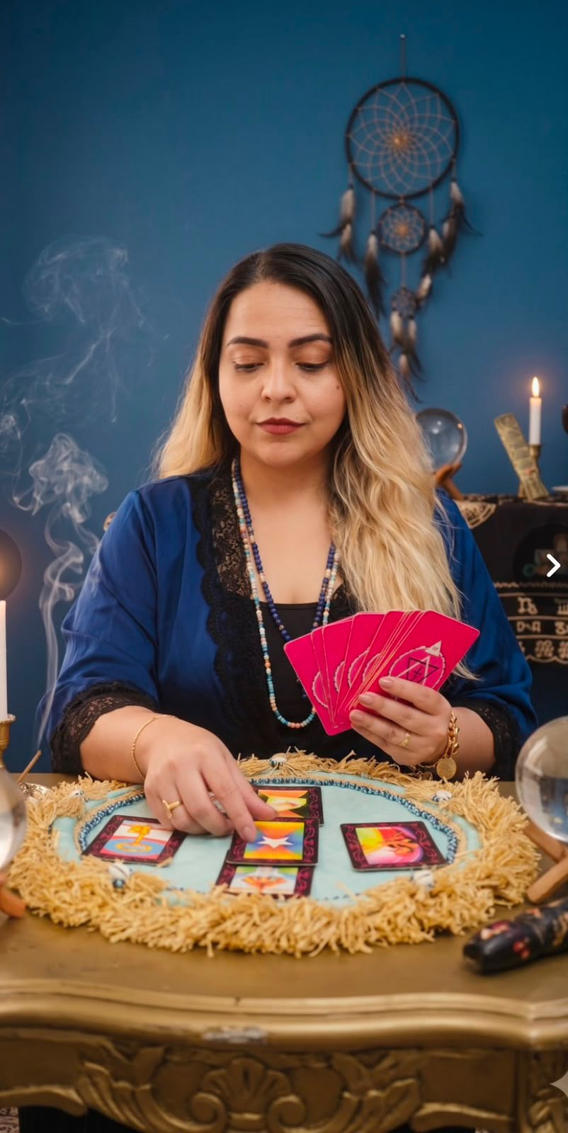 Taróloga Natália fazendo uma leitura de cartas em sua mesa de trabalho